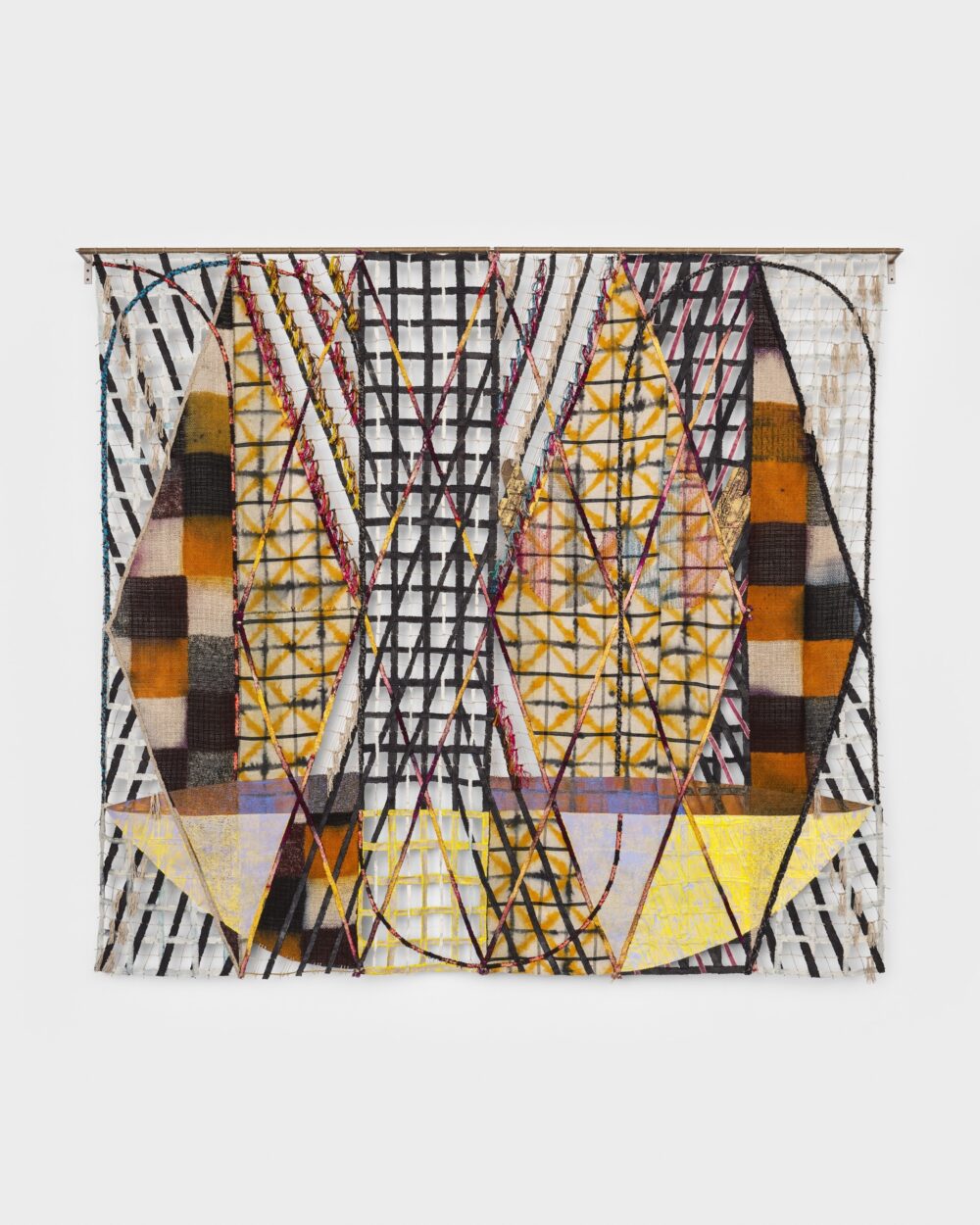 Colorful, Dyed, Woven, Braided, Tied, Hand-Sewn Monumental Tapestry hung on a white wall in a museum.