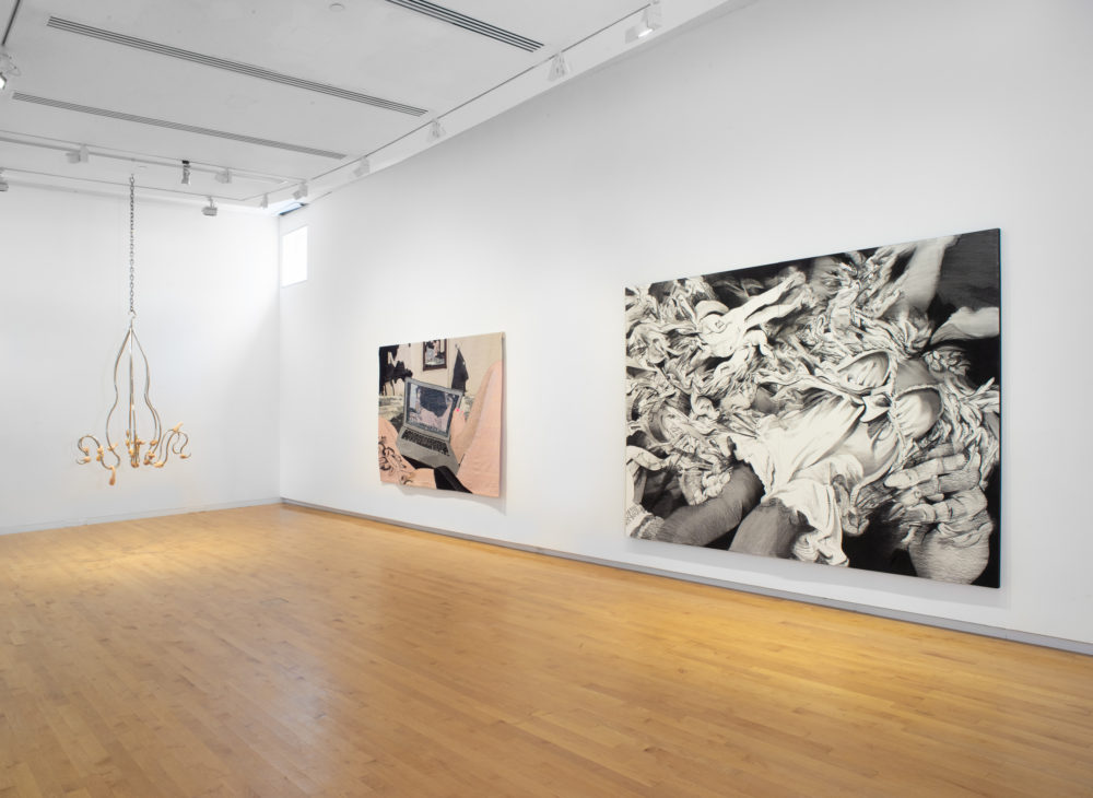 Gallery with a suspended sculpture on the far left, a tapestry at center and a large black and white work on paper at the right.