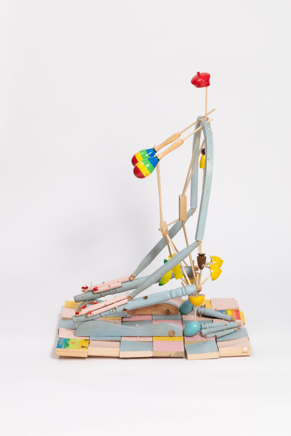 A colorful figurative sculpture in a seated zazen posture.