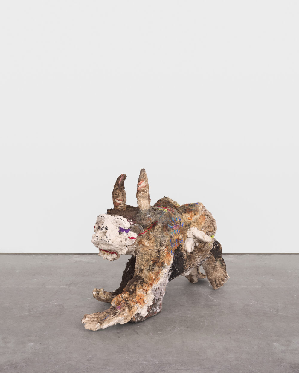 A brown, gold, and white abstract sculpture of an unknown creature on all fours.