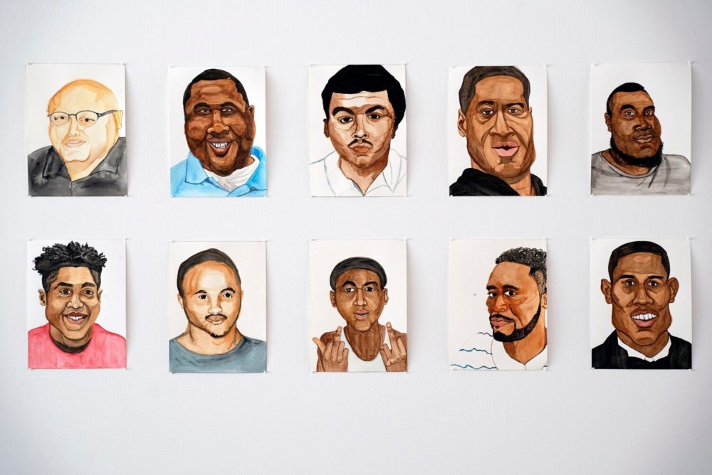 Detail of watercolor portraits against white wall