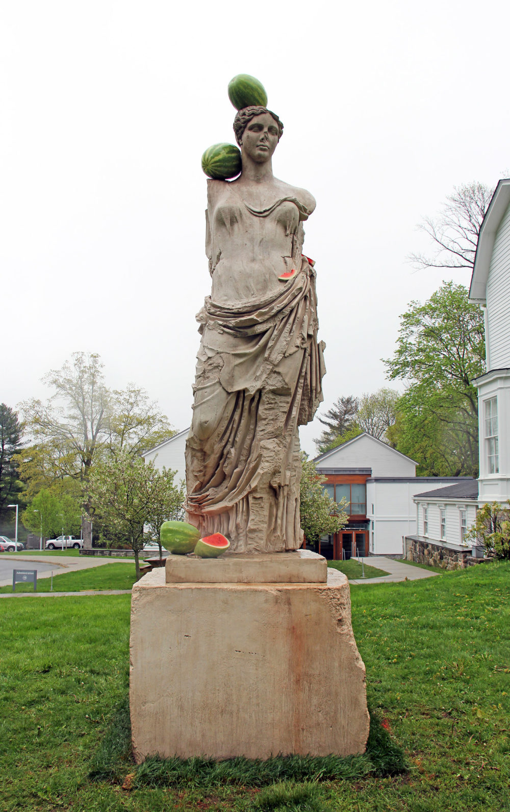 Greek statue of Hera with watermelons resting on stone figure