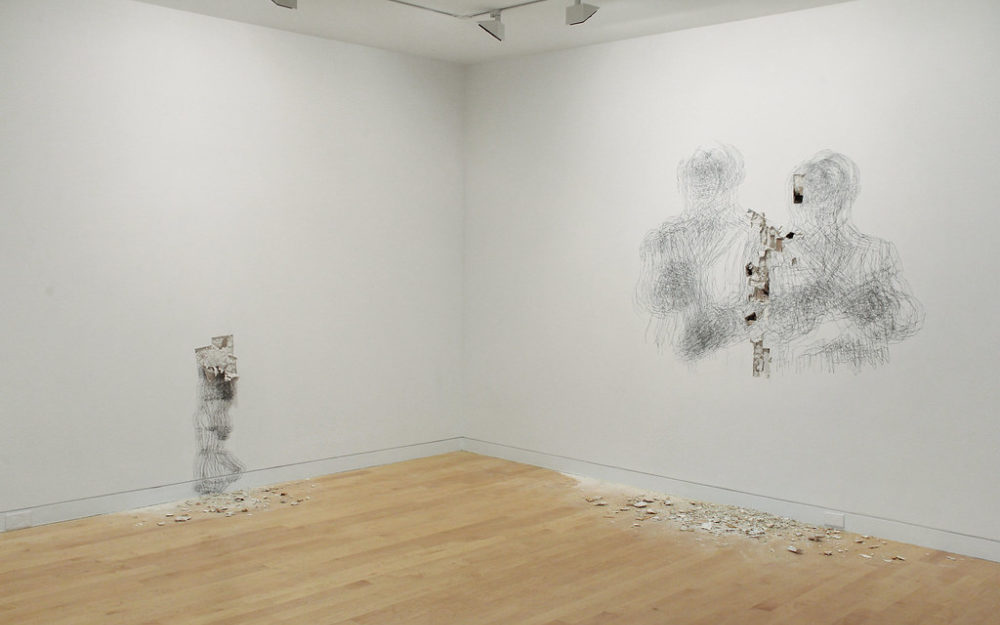 Drawings of figures on gallery walls