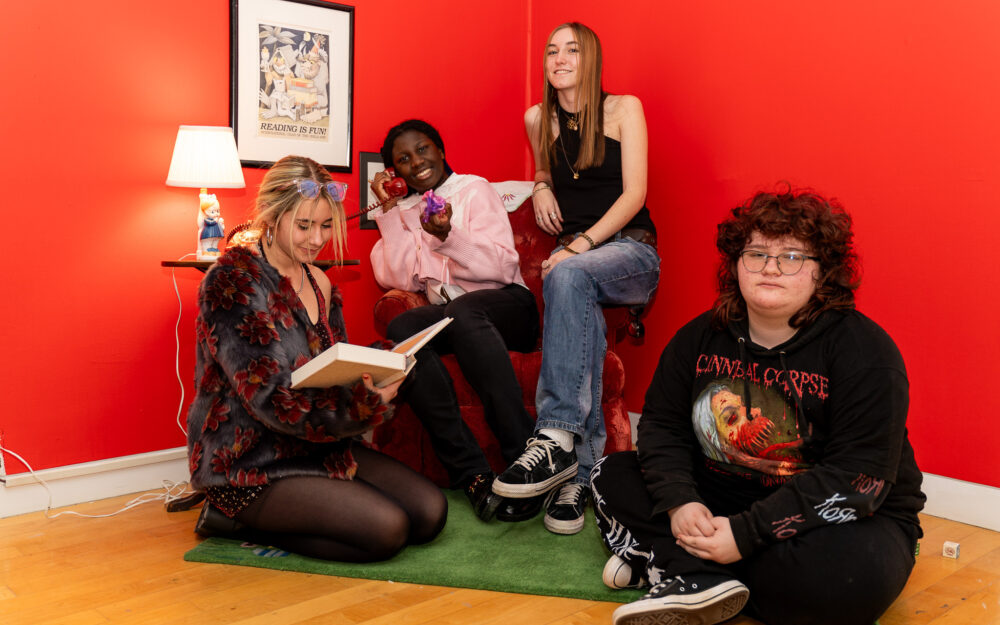 A ground of young people sitting in their art installation
