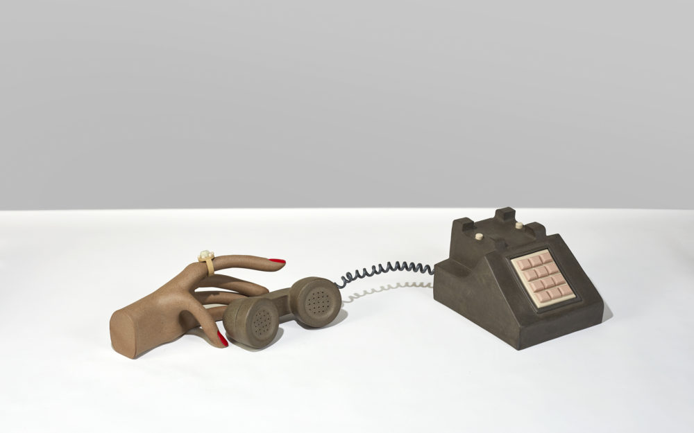 A sculpture of a hand holding a phone