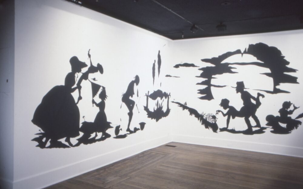 black paper cutouts plastered to white wall with story of african american experience