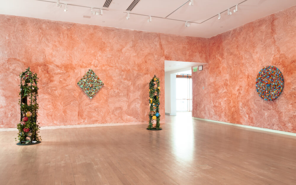 Free standing sculptures and sculptures hung on walls coated in camwood powder.