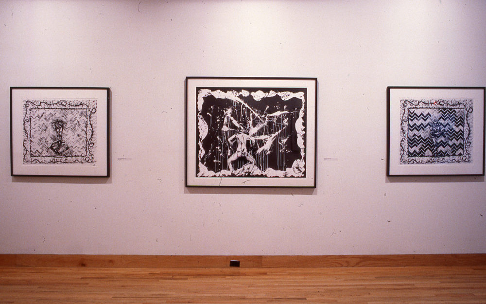 Black and white photographs against a white gallery wall