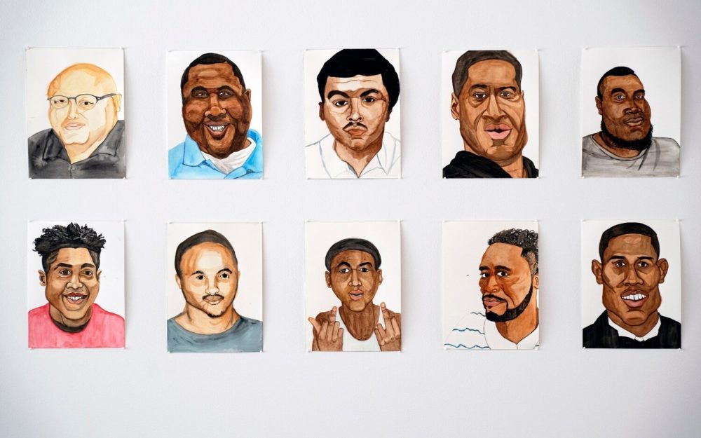 Detail of watercolor portraits against white wall