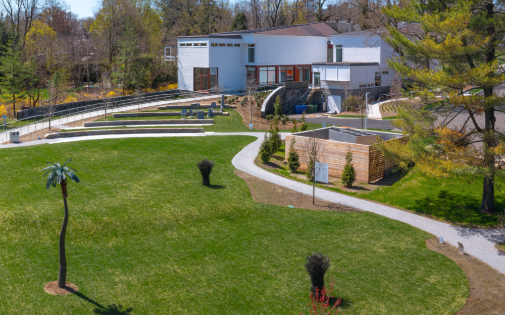 Photo of a white museum with a lavish green sculpture garden.