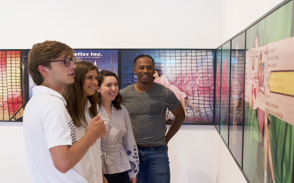 Four students look at Sara Cwynar's work