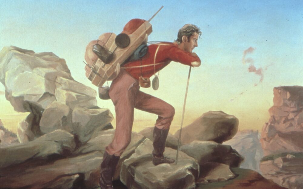 tired backpacking man looking out at the trail with a rocky backhground behind him