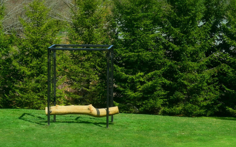 A sculpture with a suspended log in the Museum's Sculpture Garden
