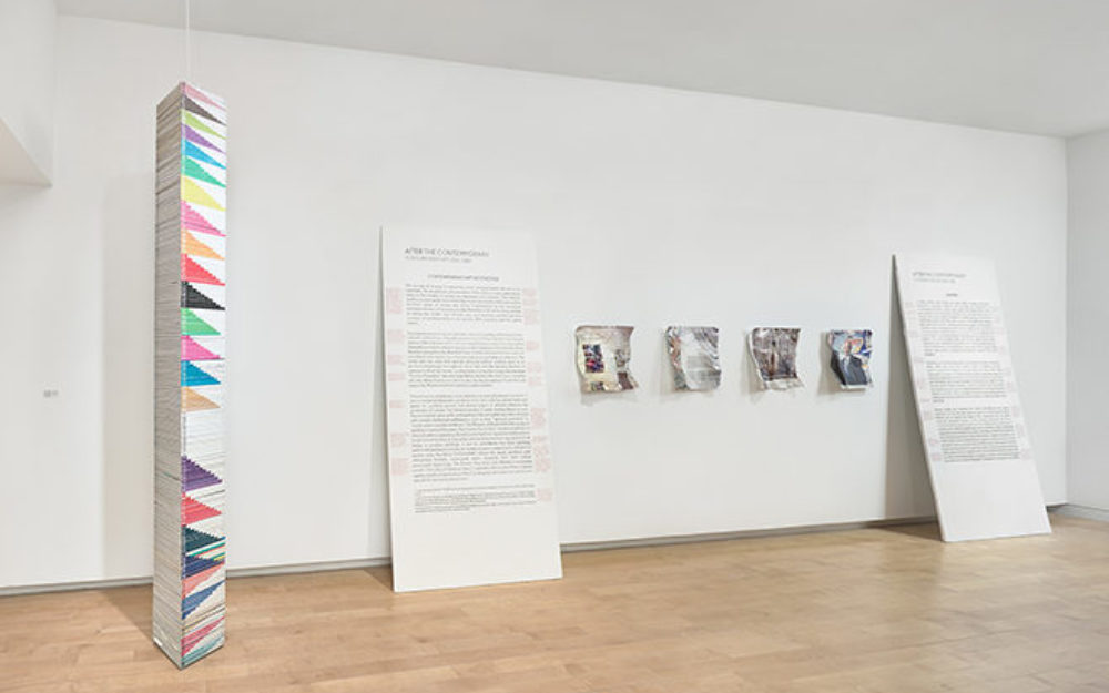 Works by artist William Powhida rest against gallery walls