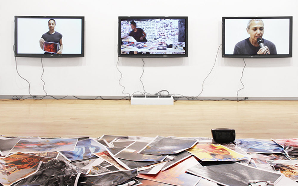 Three screens on a white gallery wall
