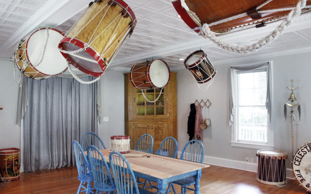 Drums float from the ceiling of a room