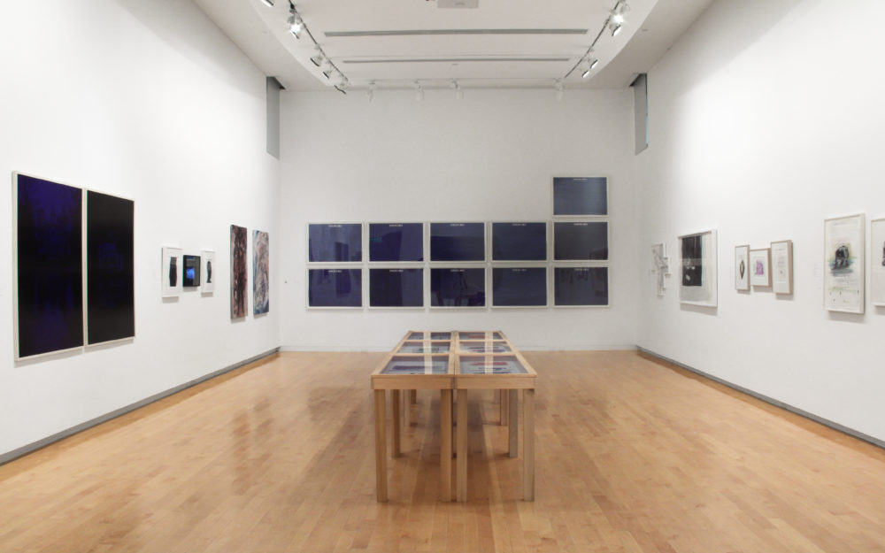 View of Ballpoint Drawing Since 1950 in The Aldrich's gallery, works hang on gallery walls and large display table sits in the middle of the room