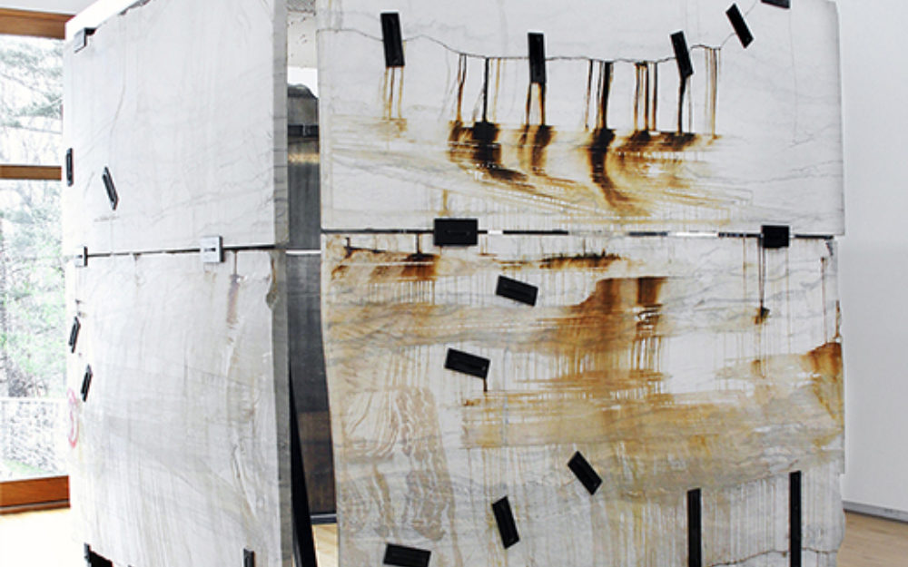 Large white box with black tape sits in the middle of a gallery space