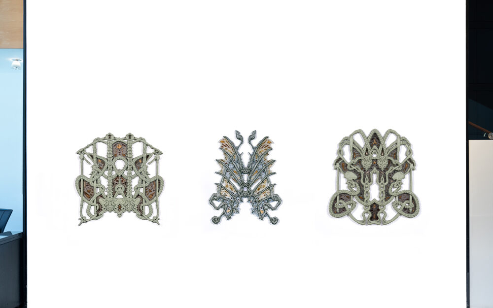 Three organically shaped wall mounted sculptures.