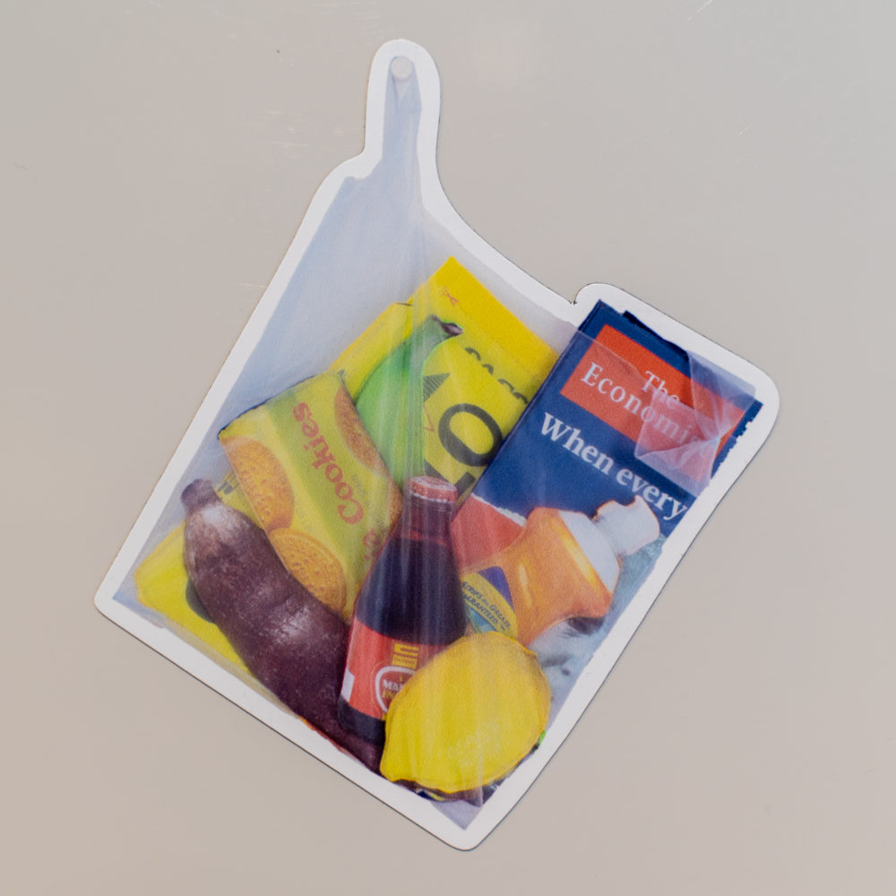 Plastic shopping bag filled with items such as: produce, a dish soap bottle, a soda bottle, magazines, and cookies.