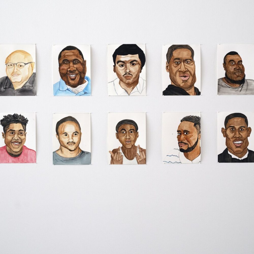 Detail of watercolor portraits against white wall