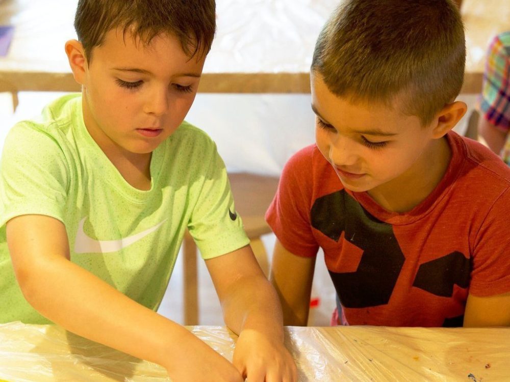 Two young children work on an art project
