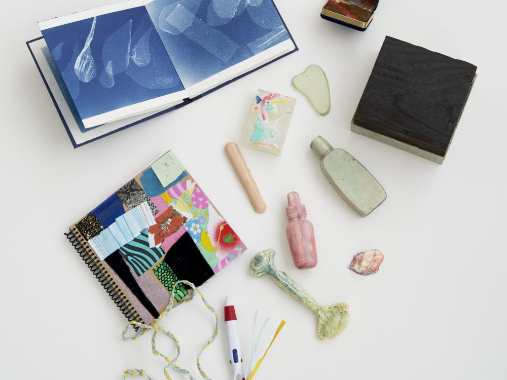 The art contents of the Aldrich Care Box featuring two artists' books and small sculptures.