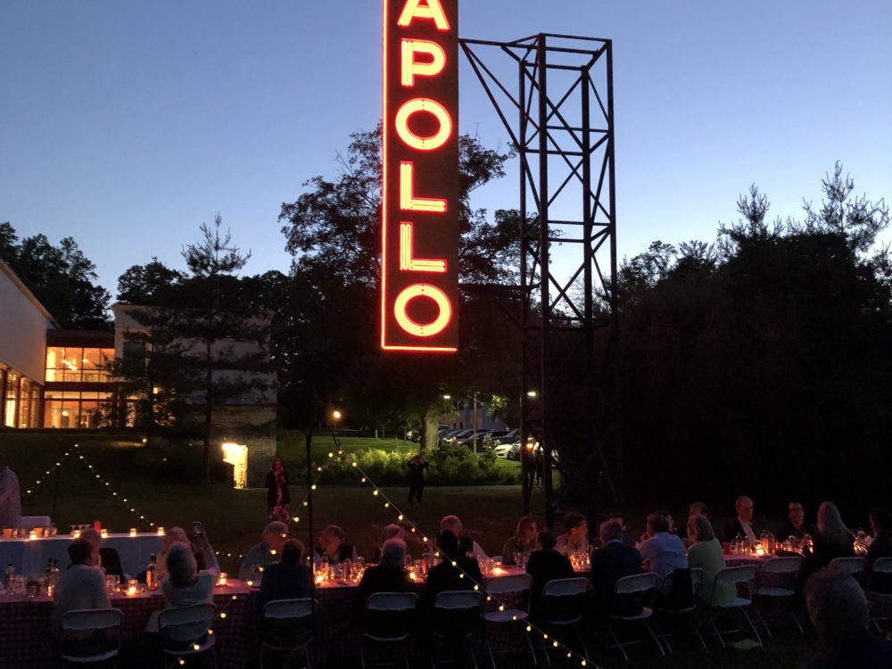 People enjoying dinner al fresco in the Sculpture Garden underneath Nari Ward's sculpture Apollo / Poll.