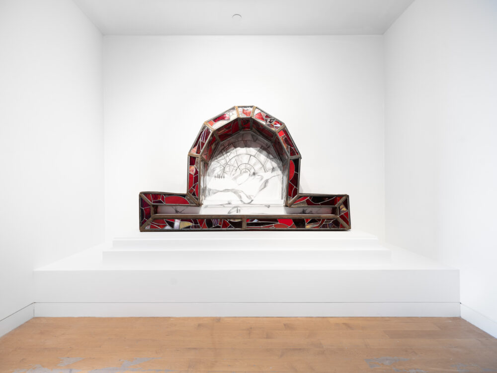 A stained glass architectural form with a pencil drawing inside.