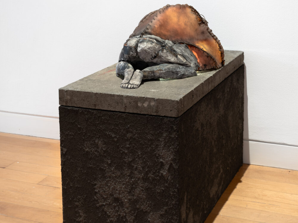 A small scale figurative sculpture on a cement base.