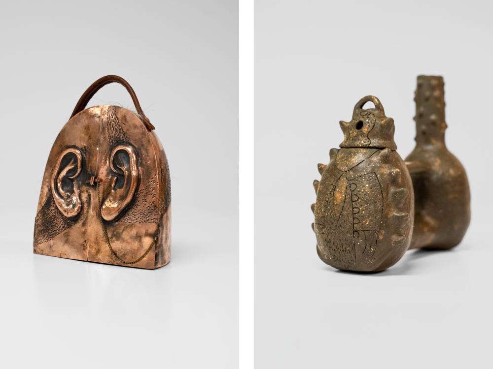 Two brown handheld sculptures. The one on the left has ears, french doors, and a handle. The one on the right is a traditional whistling jar.