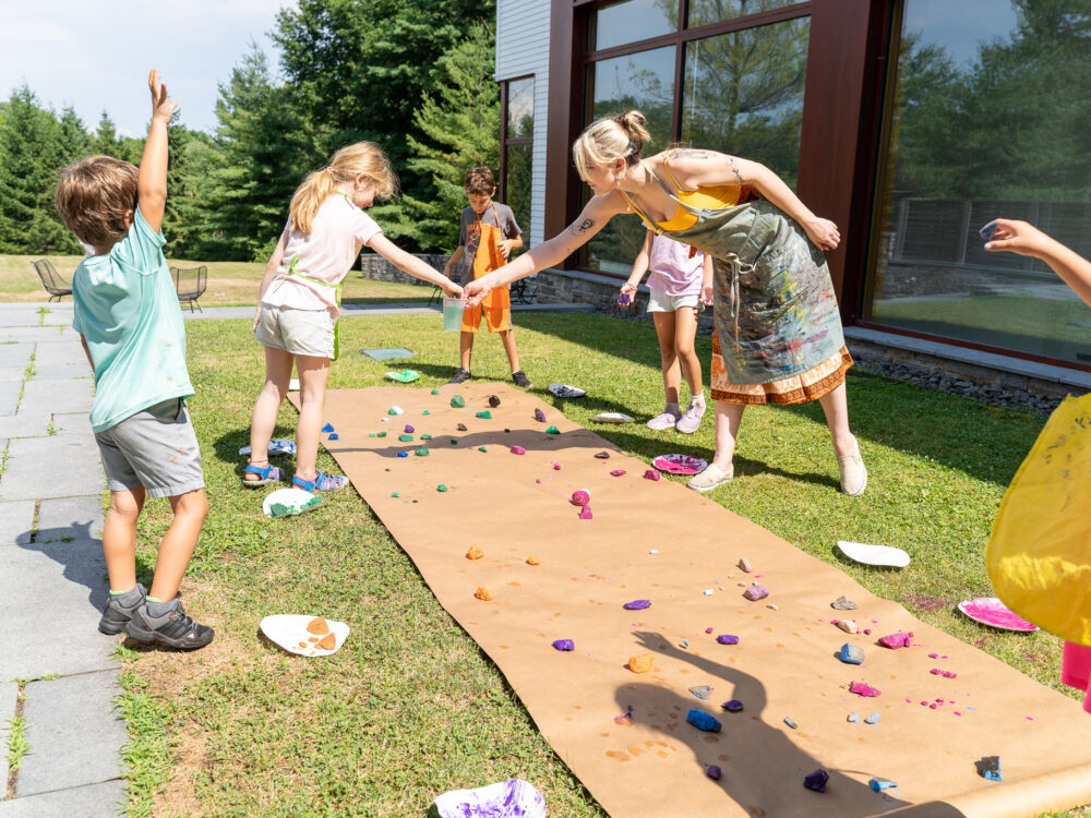 Campers making art outside with teacher