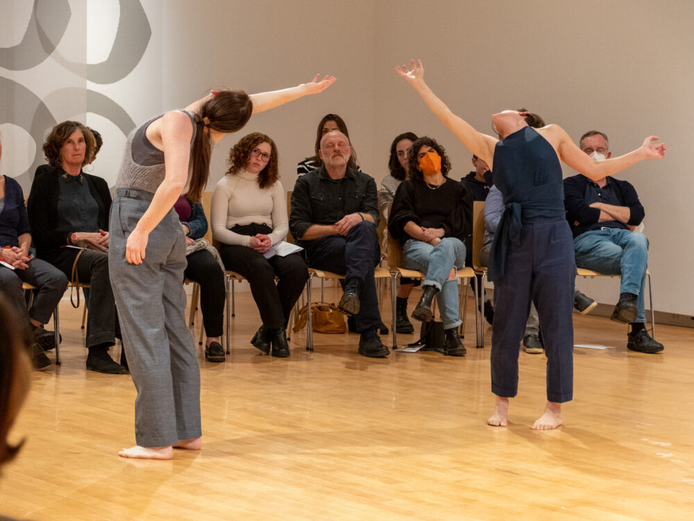 Two dancers with arms outstretched