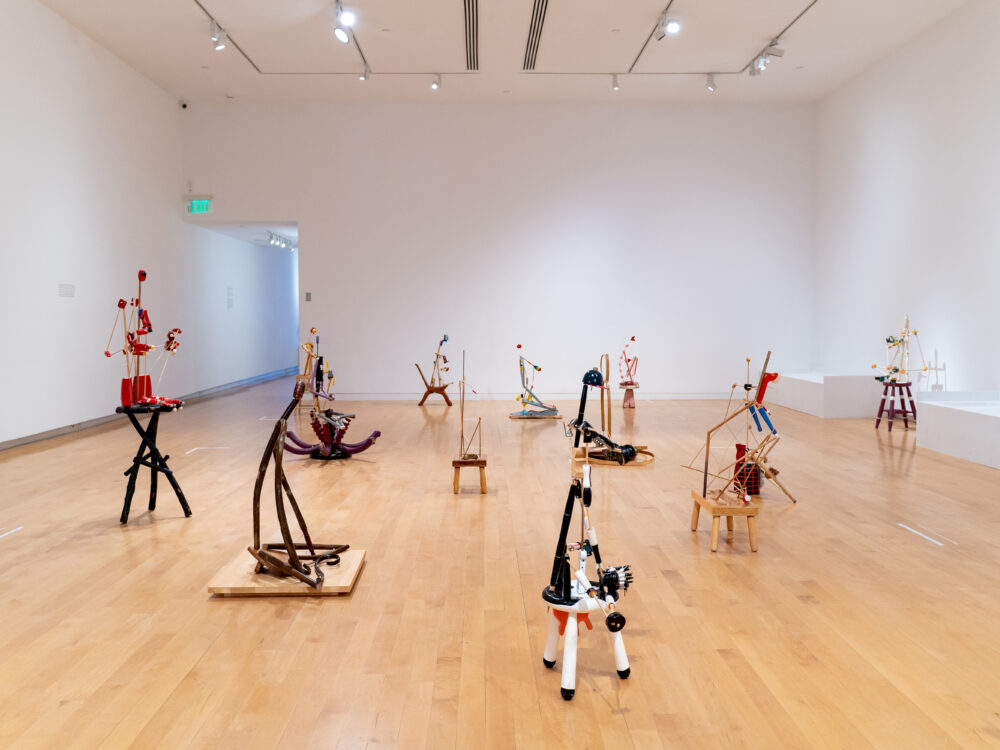 A side view of sculptures on the floor in a gallery.