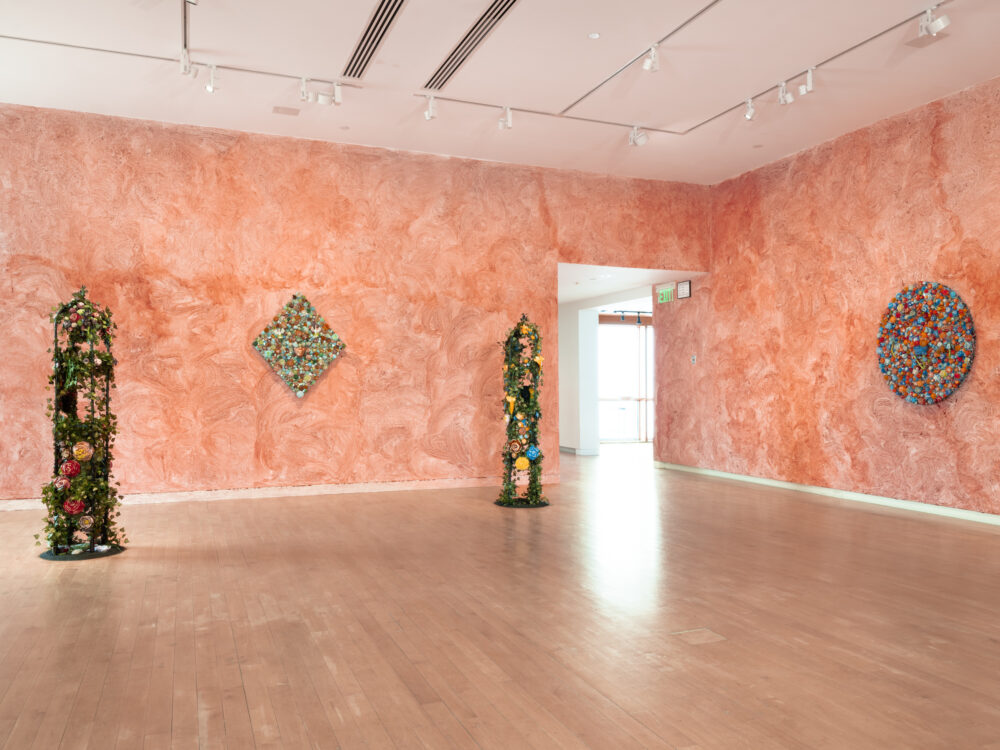 Free standing sculptures and sculptures hung on walls coated in camwood powder.