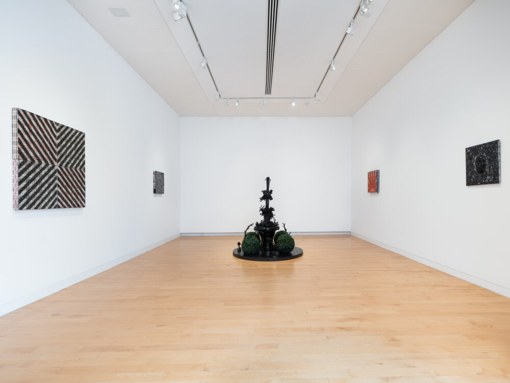 A black glass fountain with wall mounted works.