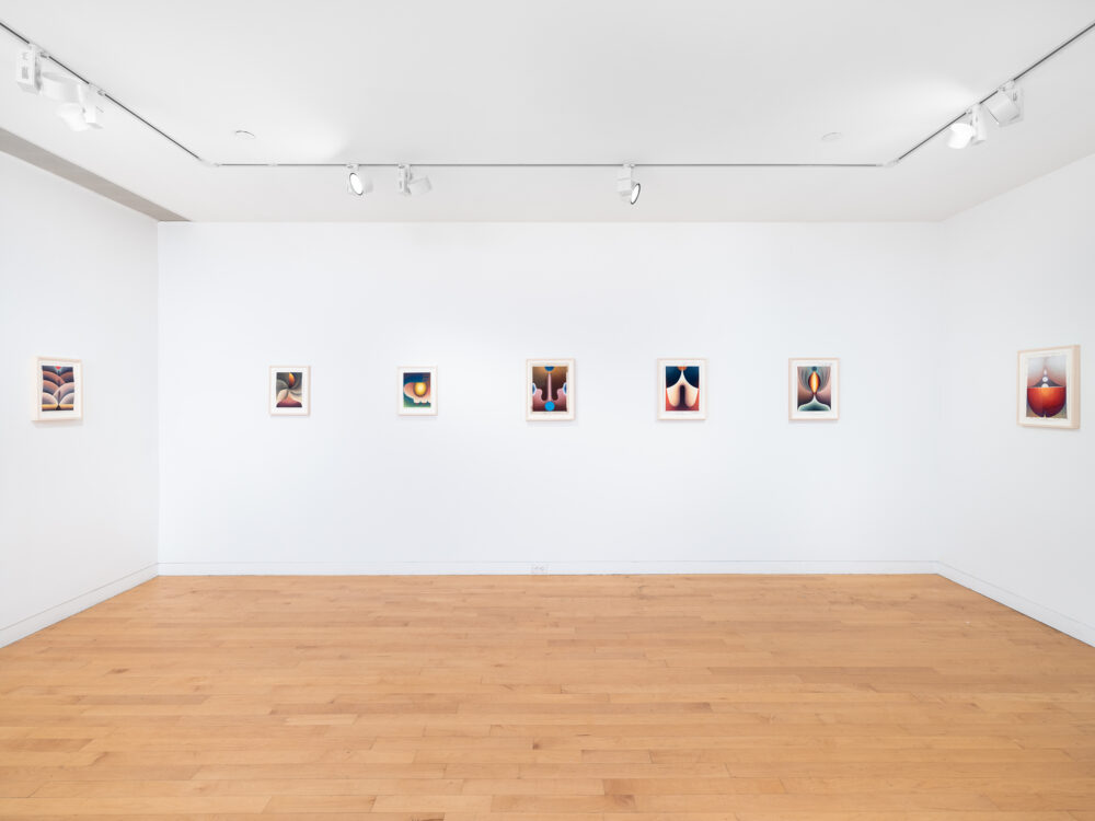 A row of small framed colorful drawings hung on three walls in a gallery