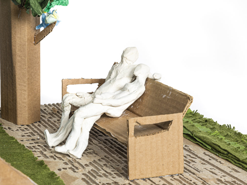 Two figures seated on a park bench