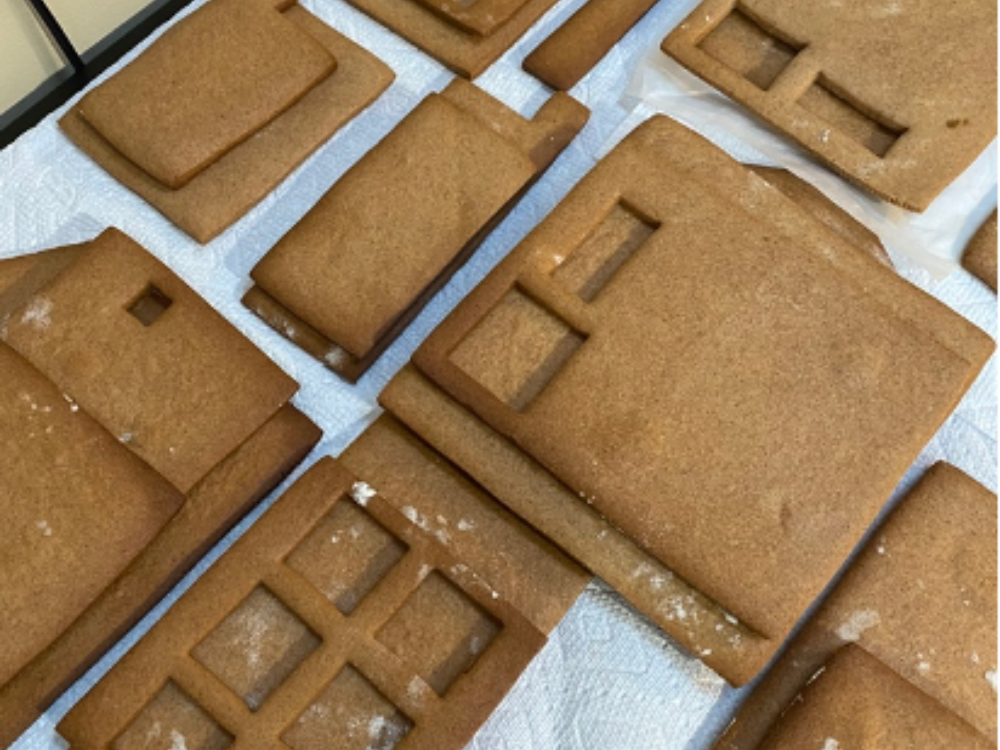 Gingerbread house pieces with window cutouts against a white background