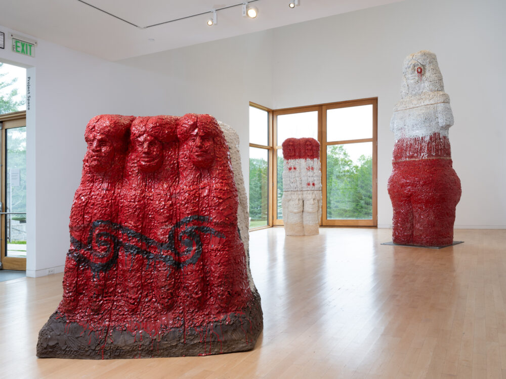 Three large scale figurative ceramic sculptures in a gallery.