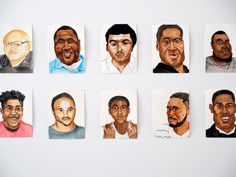 Detail of watercolor portraits against white wall