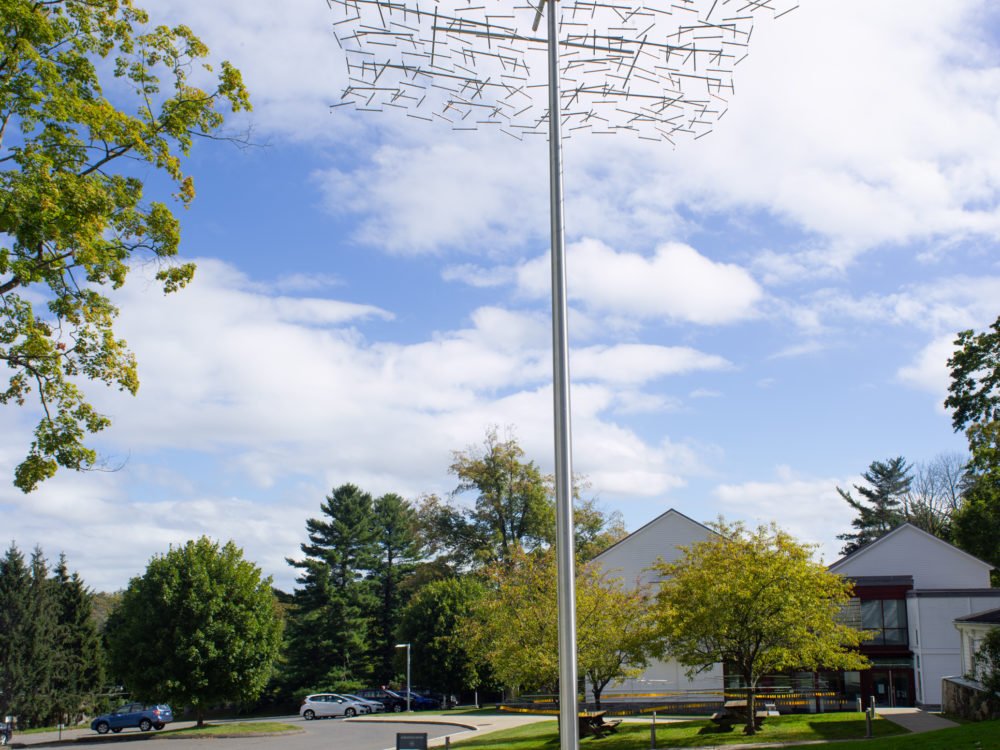Tall steel pole with a kinetic sculpture on top.