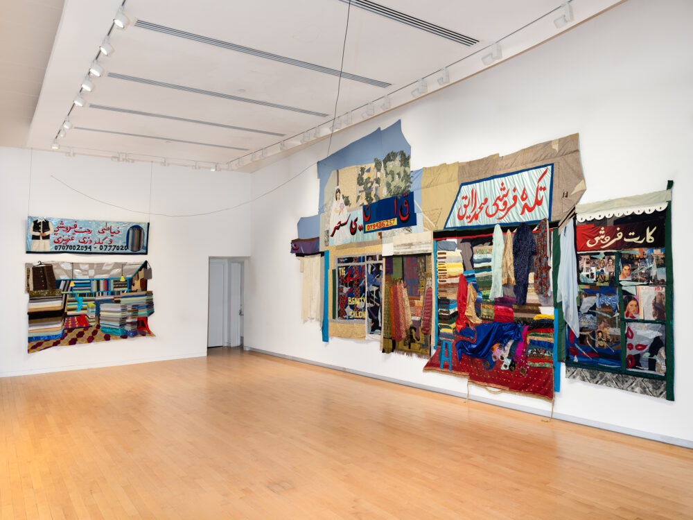 A museum gallery with large-scale tapestries hanging on the walls
