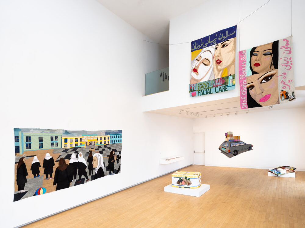 A museum gallery with textile works such as tapestries and soft sculptures.