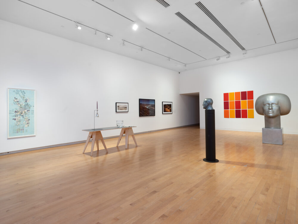 A museum gallery with various artworks relating to the periodic table of elements on display