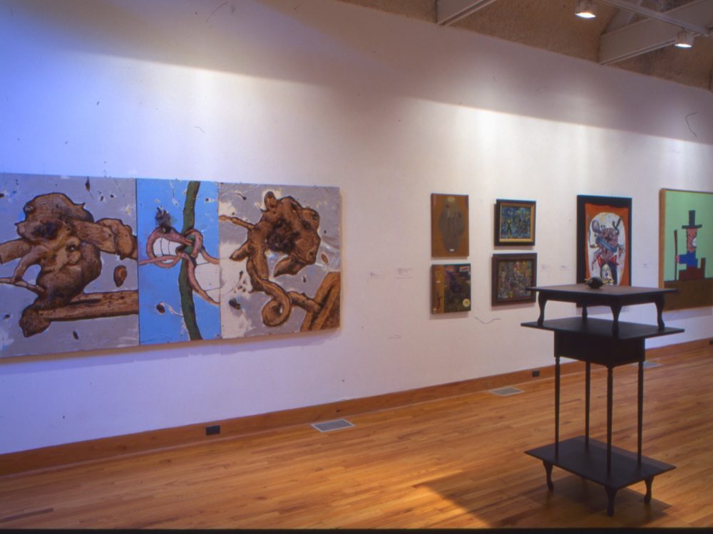 This is a photograph of the Pop Surrealism exhibition which has many vibrant works on display.